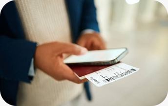 A person holding a smartphone along with a passport and boarding pass, preparing for a flight or travel check-in.